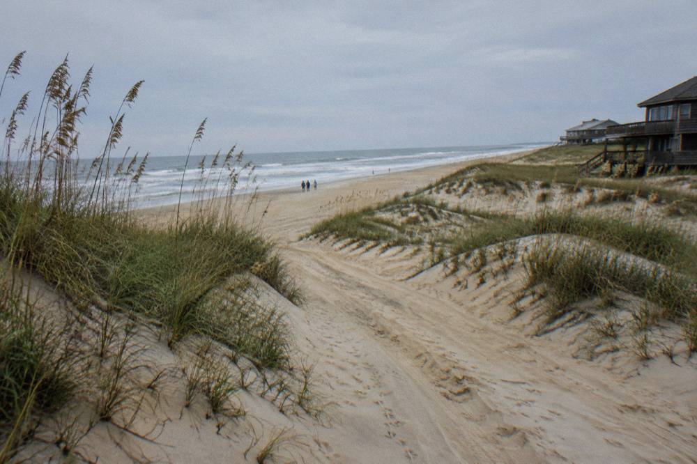 Sand tracks on a wide northern Outer Banks beach with low dunes and open sky