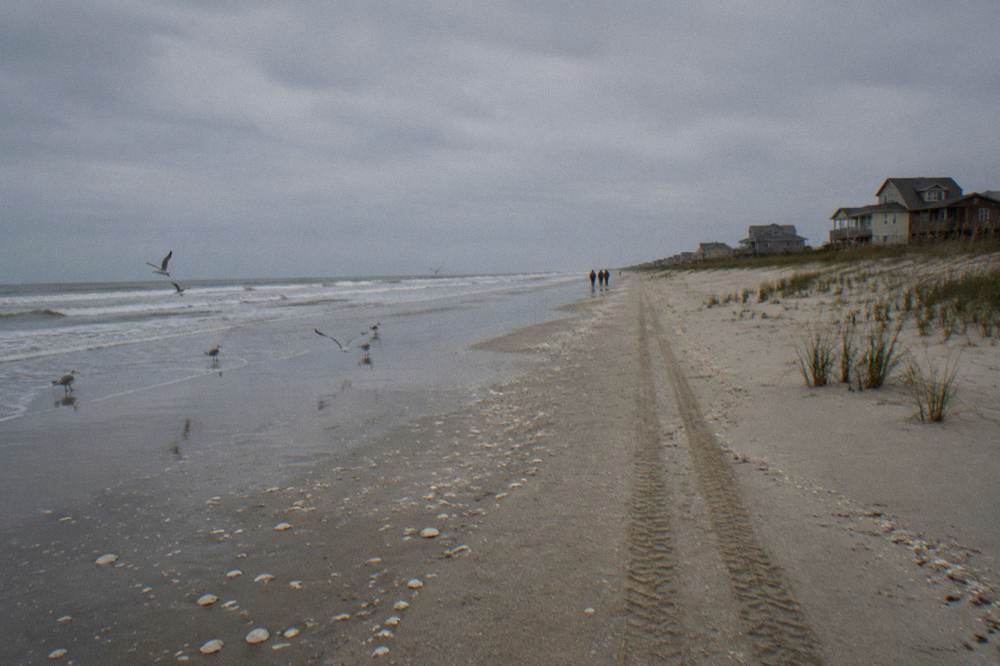 Open sandy beach near Corolla with sea oats on low dunes under a wide sky