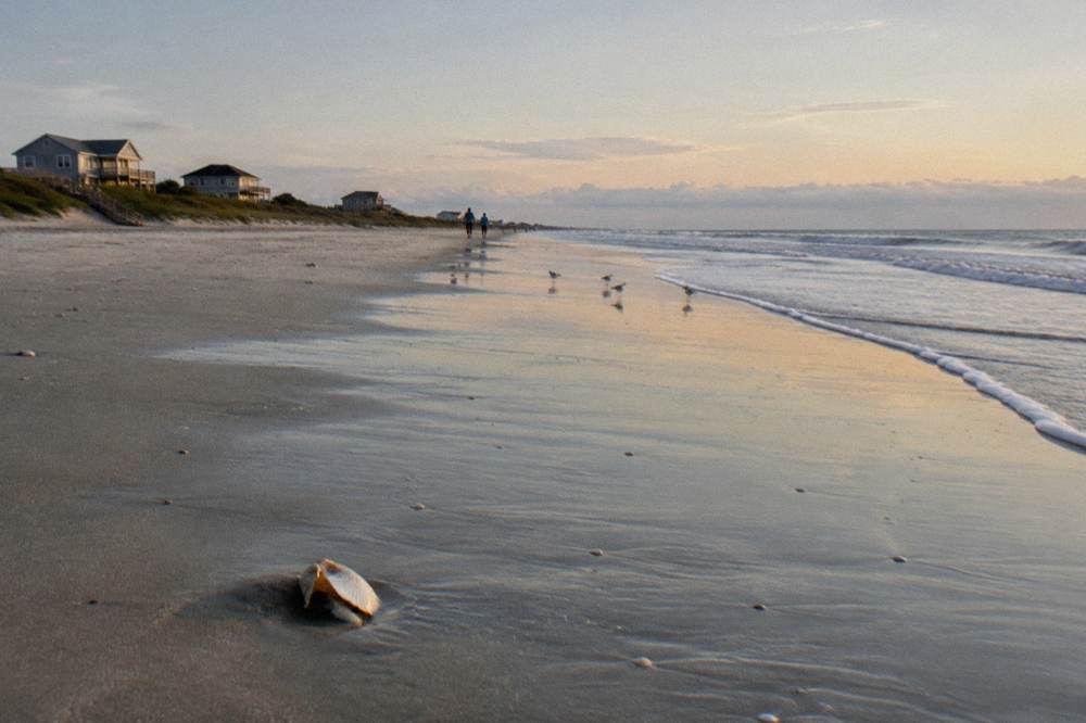 Calm morning light over a wide beach with gentle surf