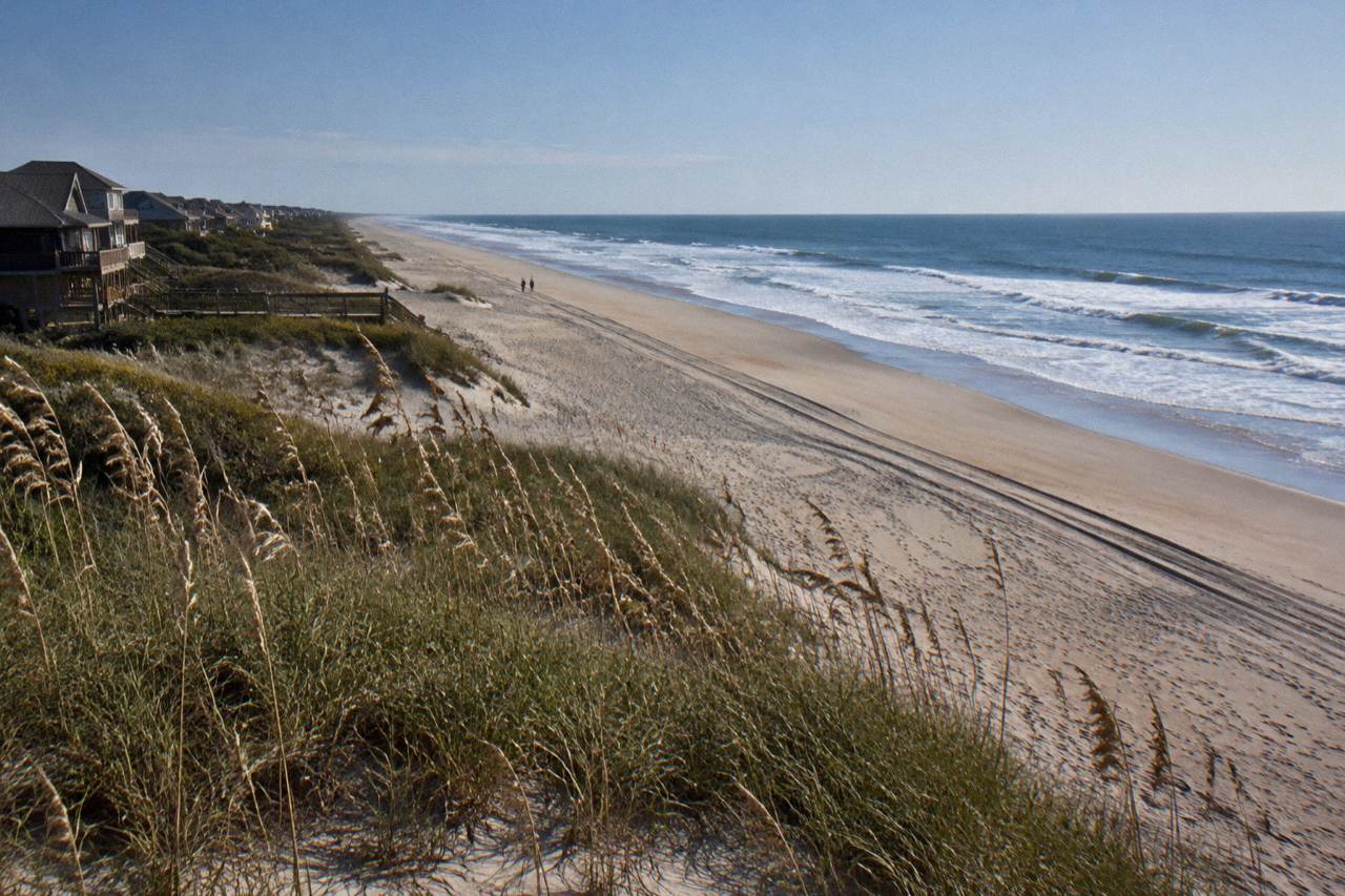 Wide empty beach at the northern end of Corolla with dune grass and open sky