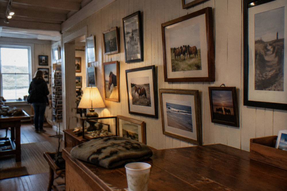 Exhibit wall with framed photographs inside a small museum interior