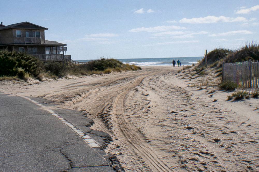 An open stretch of northern Outer Banks beach with vehicle tracks in the sand