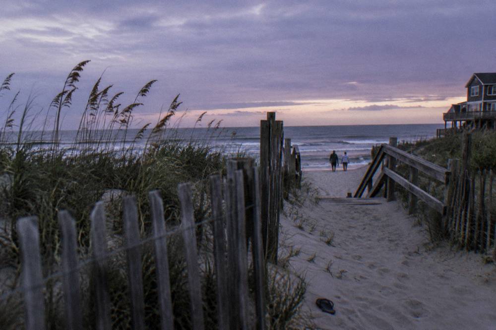 Beach access point at Corolla with soft sand and sea oats on the dune line under wide sky