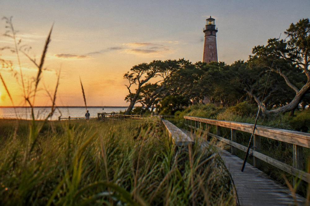 Boardwalk path through marsh grass toward Currituck Sound at sunset
