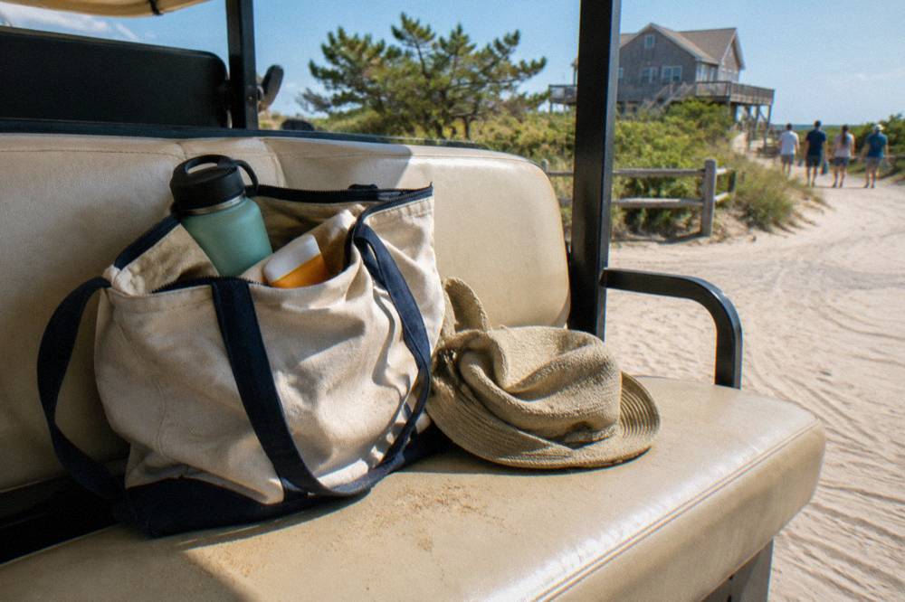 Beach bag with water bottle, sunscreen and sun hat resting on a truck seat