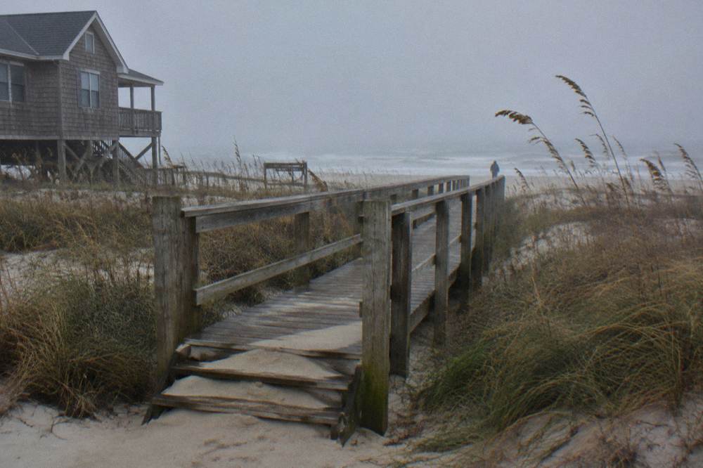 Wooden walkway leading from a rental house over the dune to the open beach